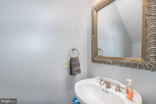 bathroom with a sink and lofted ceiling