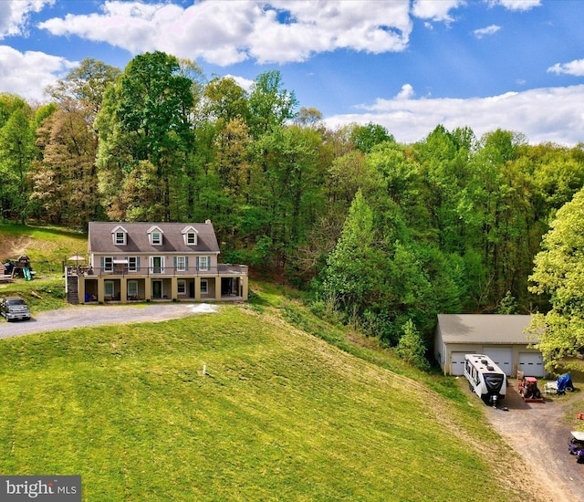 aerial view of property and surrounding area featuring a heavily wooded area