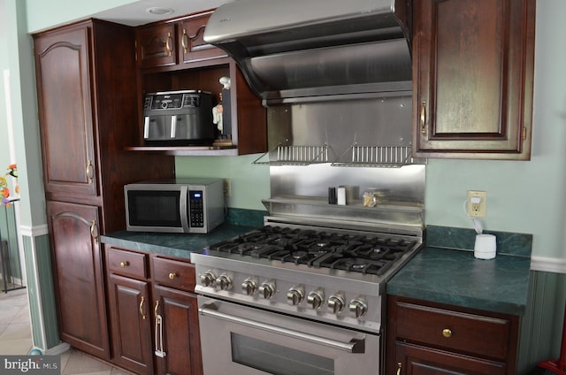 kitchen with stainless steel appliances, dark countertops, and light tile patterned floors