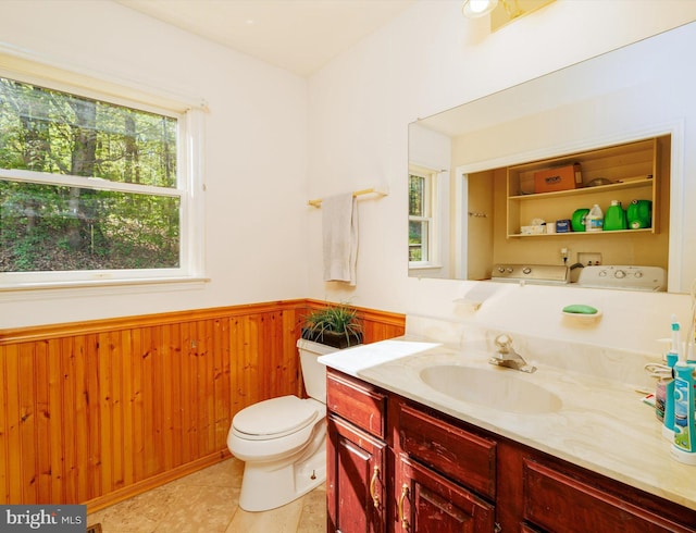bathroom featuring wainscoting, vanity, toilet, wooden walls, and tile patterned floors
