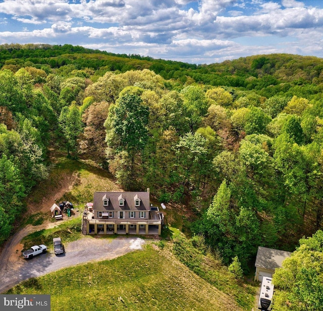 aerial view of property and surrounding area with a heavily wooded area
