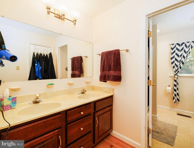 bathroom with double vanity and baseboards
