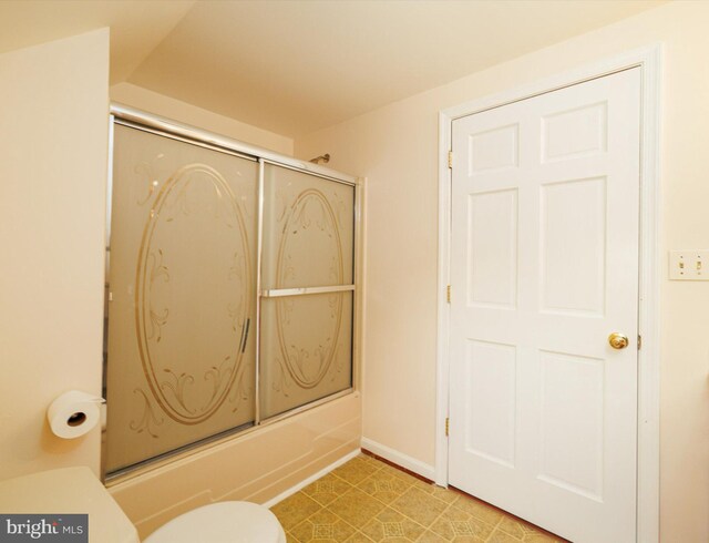 full bath with toilet, bath / shower combo with glass door, and baseboards