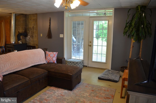 living area with ceiling fan and a wood stove