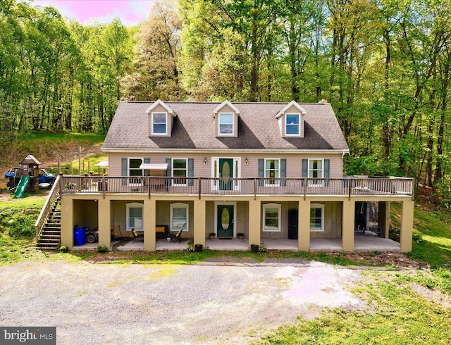 multi unit property with a wooden deck, a patio area, and stairs
