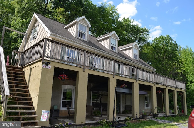 rear view of property with stairway, a shingled roof, and a wooden deck