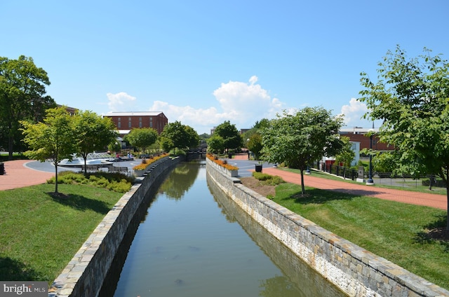 view of property's community featuring a yard and a water view