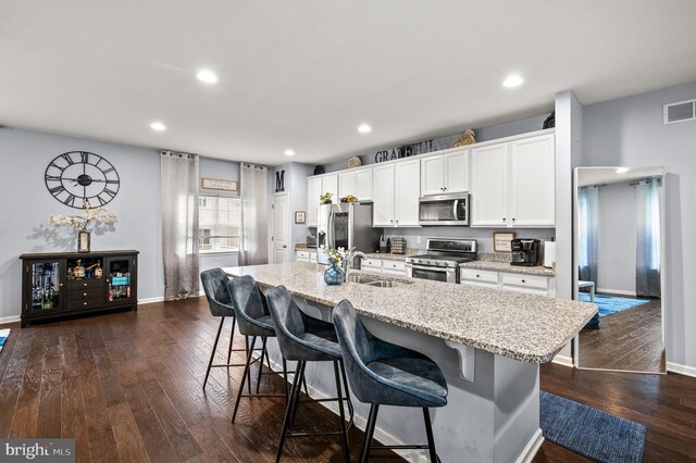 131 Time Cir, Bear, DE 19701 - kitchen with dark wood finished floors, appliances with stainless steel finishes, a kitchen island with sink, and a breakfast bar area