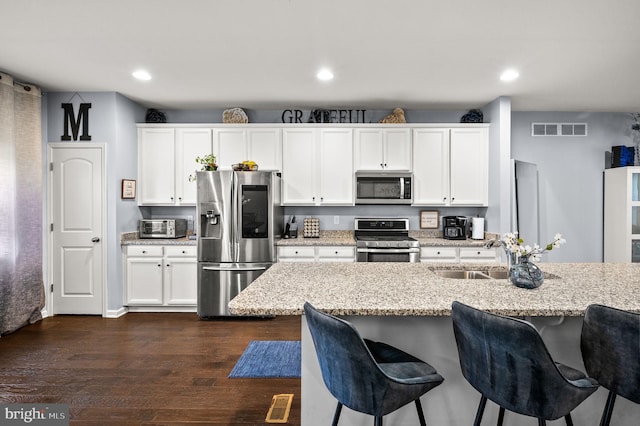 131 Time Cir, Bear, DE 19701 - kitchen featuring a kitchen breakfast bar, a sink, appliances with stainless steel finishes, dark wood-type flooring, and visible vents