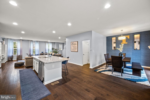 131 Time Cir, Bear, DE 19701 - kitchen with an island with sink, dark wood-style floors, a breakfast bar, dishwasher, and baseboards