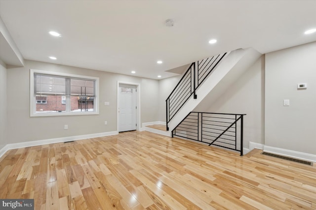 interior space featuring baseboards, visible vents, recessed lighting, wood finished floors, and stairs