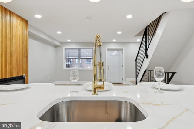 interior details with recessed lighting, light stone counters, and a sink