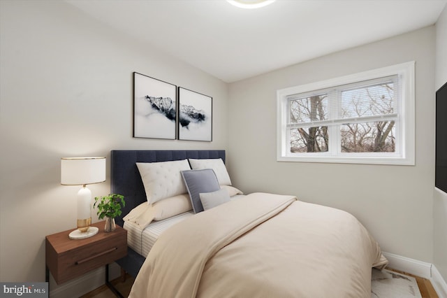 bedroom featuring baseboards and wood finished floors