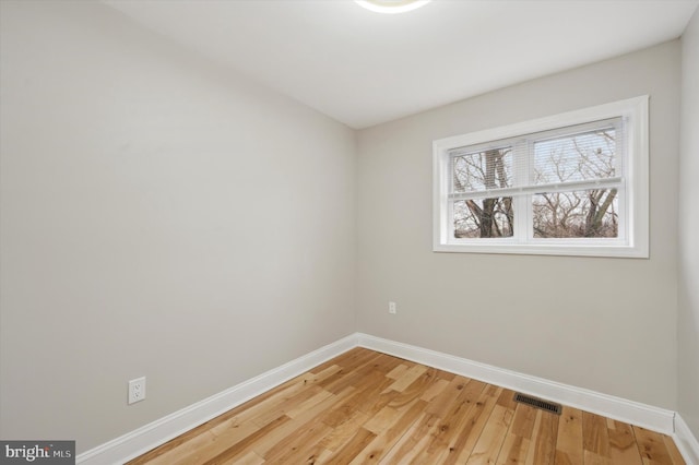 spare room featuring visible vents, baseboards, and light wood-type flooring
