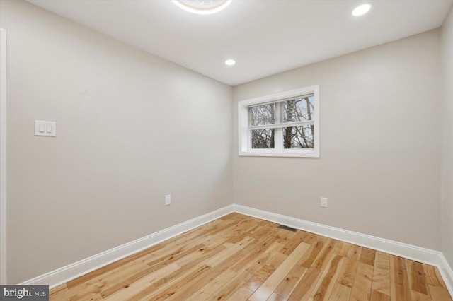 spare room with recessed lighting, wood finished floors, visible vents, and baseboards