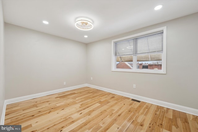 spare room with recessed lighting, hardwood / wood-style floors, visible vents, and baseboards