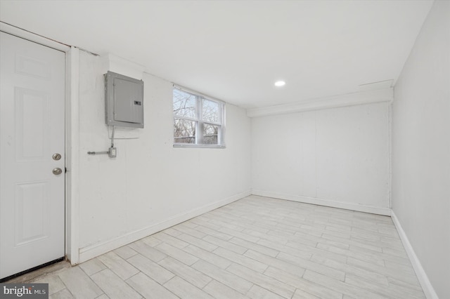 basement with recessed lighting, electric panel, and baseboards