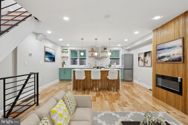 kitchen featuring a center island, open shelves, light wood-style floors, light countertops, and freestanding refrigerator