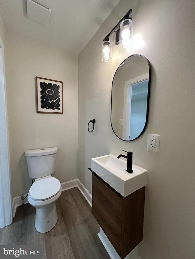 2452 Shirley Ave, Baltimore, MD 21215 - bathroom with wood finished floors, toilet, vanity, and baseboards