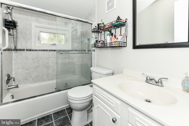 full bath with toilet, vanity, tile patterned floors, and shower / bath combination with glass door