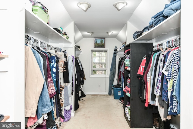 walk in closet with vaulted ceiling and carpet
