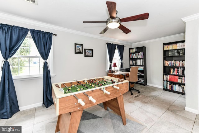rec room featuring a ceiling fan, baseboards, and ornamental molding