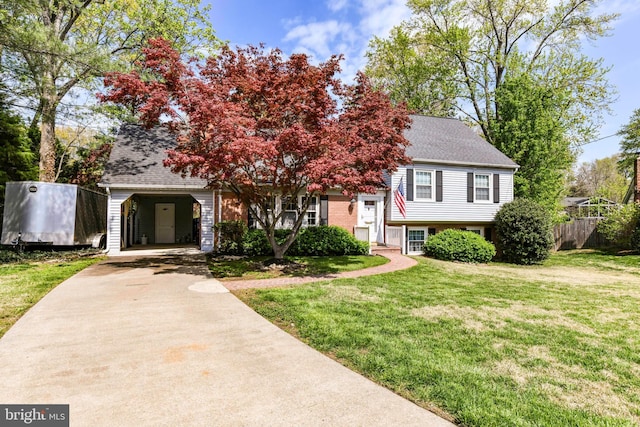 view of front facade featuring driveway, a carport, roof with shingles, and a front yard