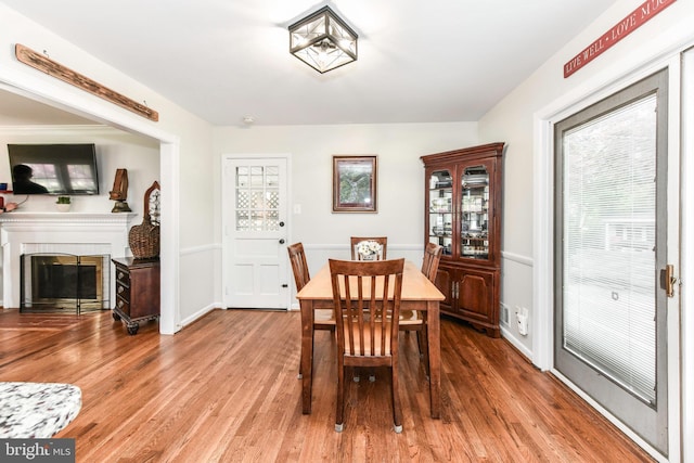 dining room with a glass covered fireplace and wood finished floors
