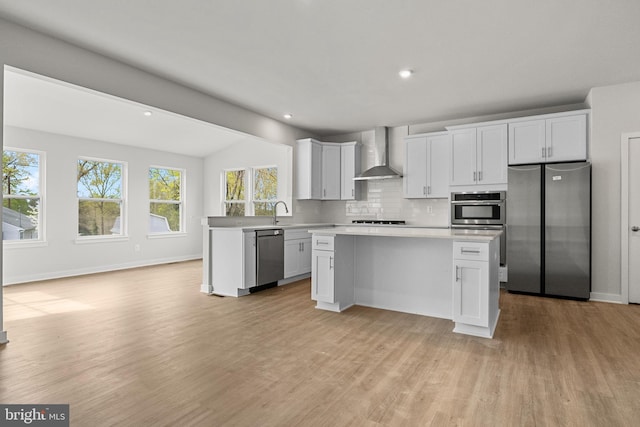 109 Hillsdale Dr, Fredericksburg, VA 22405 - kitchen with appliances with stainless steel finishes, wall chimney exhaust hood, light countertops, light wood-style flooring, and backsplash