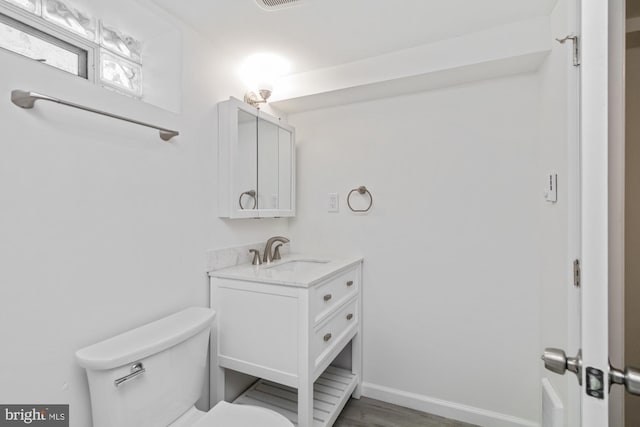4 Cavan Dr, Lutherville Timonium, MD 21093 - half bathroom featuring wood finished floors, visible vents, toilet, vanity, and baseboards