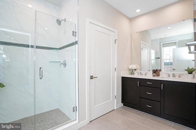 full bathroom with a sink, double vanity, and a stall shower