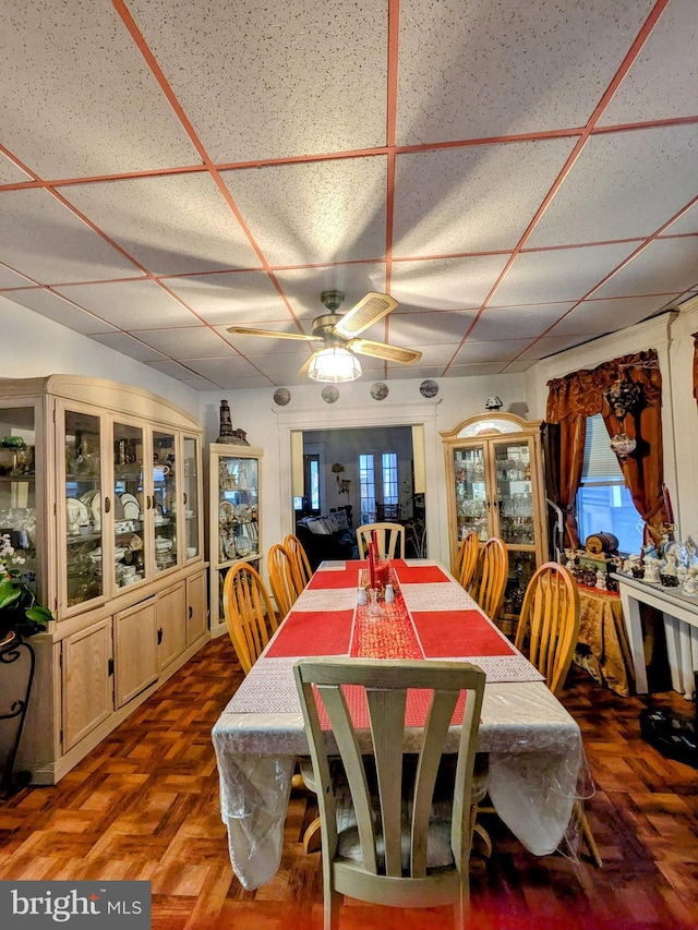 dining room with a drop ceiling and ceiling fan