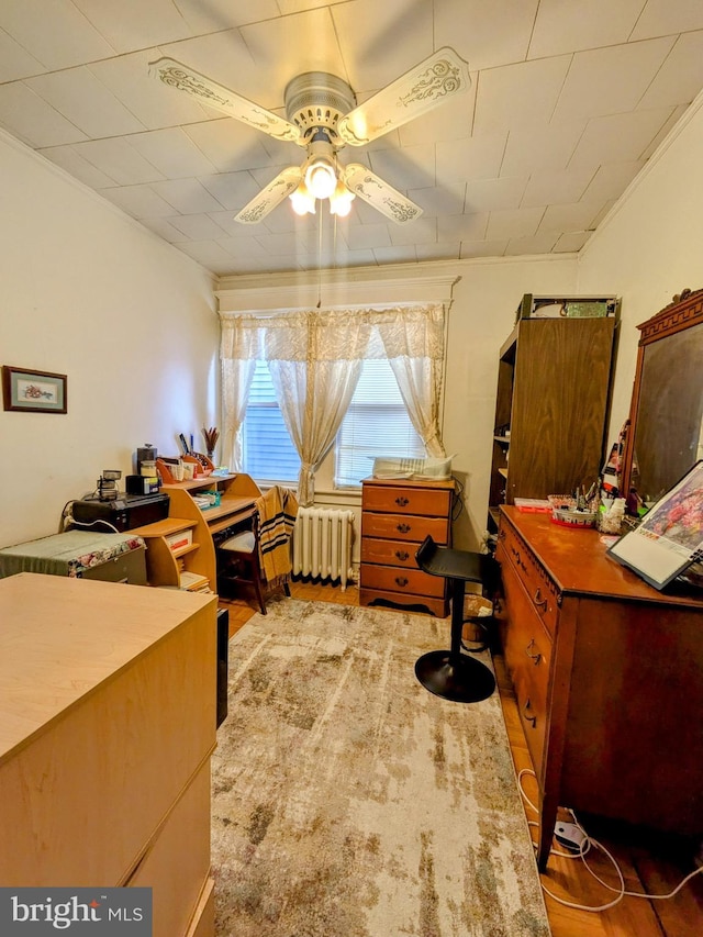 bedroom with radiator heating unit and wood finished floors