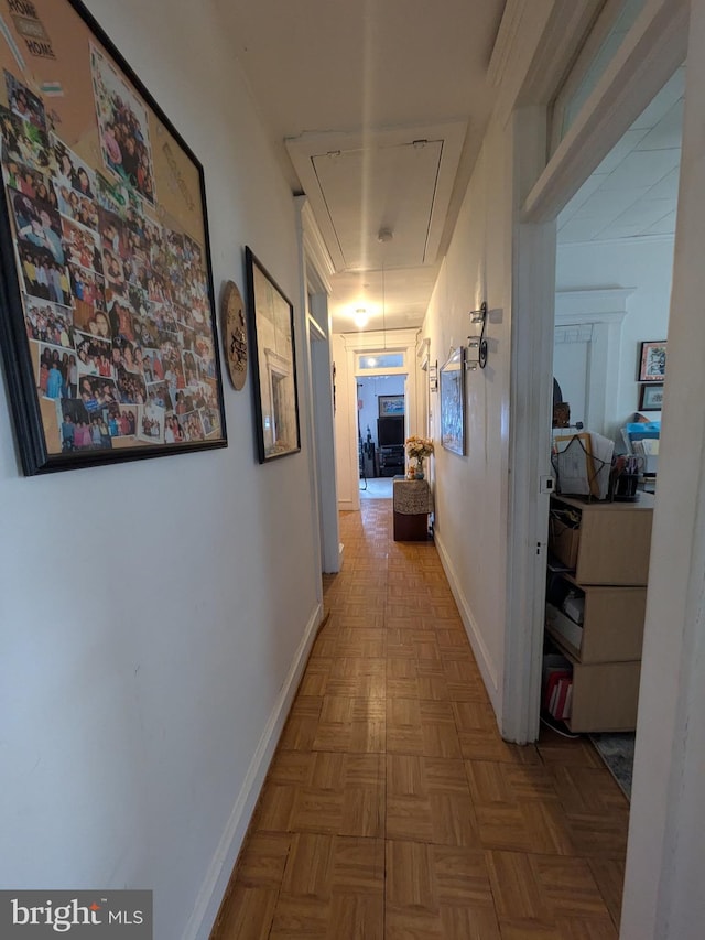 corridor with attic access and baseboards