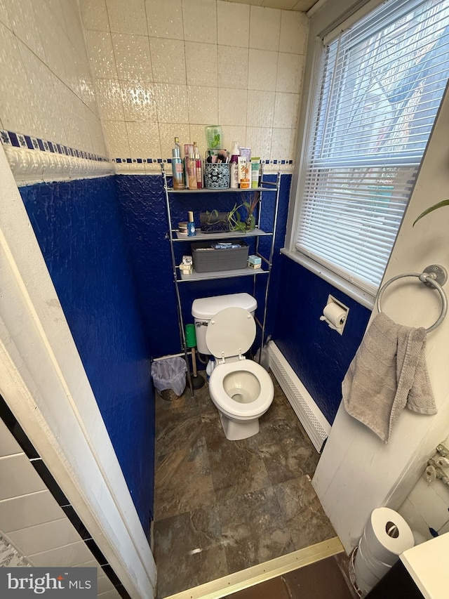 bathroom with a baseboard heating unit, baseboards, and toilet