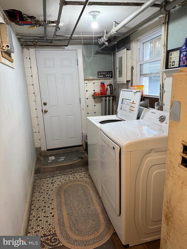 clothes washing area featuring washer and dryer, baseboards, and laundry area