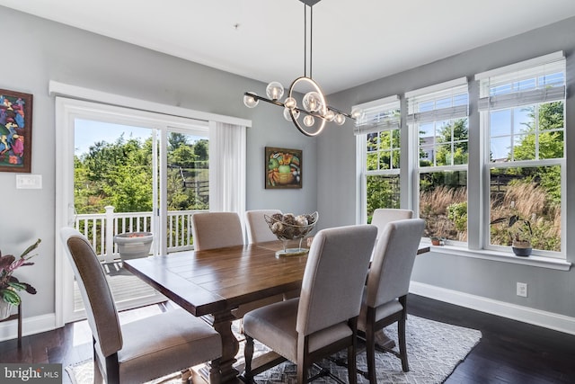 dining space featuring baseboards, dark wood finished floors, and an inviting chandelier