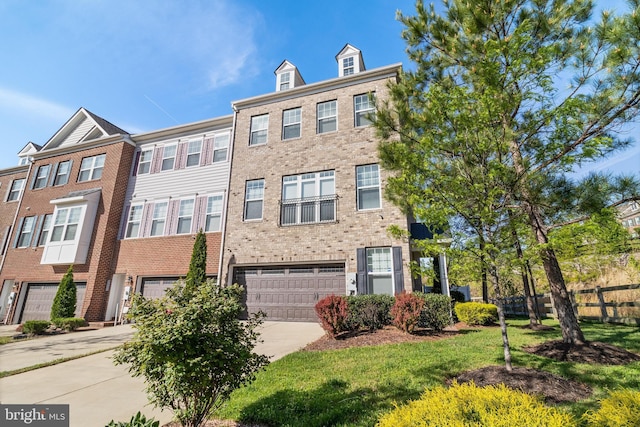 view of property with an attached garage, fence, driveway, and brick siding