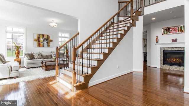 13002 Walkers Ln, Bowie, MD 20721 - stairs featuring a glass covered fireplace, baseboards, wood finished floors, and a towering ceiling