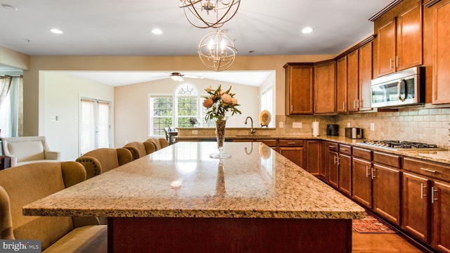 13002 Walkers Ln, Bowie, MD 20721 - kitchen with appliances with stainless steel finishes, decorative backsplash, a breakfast bar area, and ceiling fan with notable chandelier