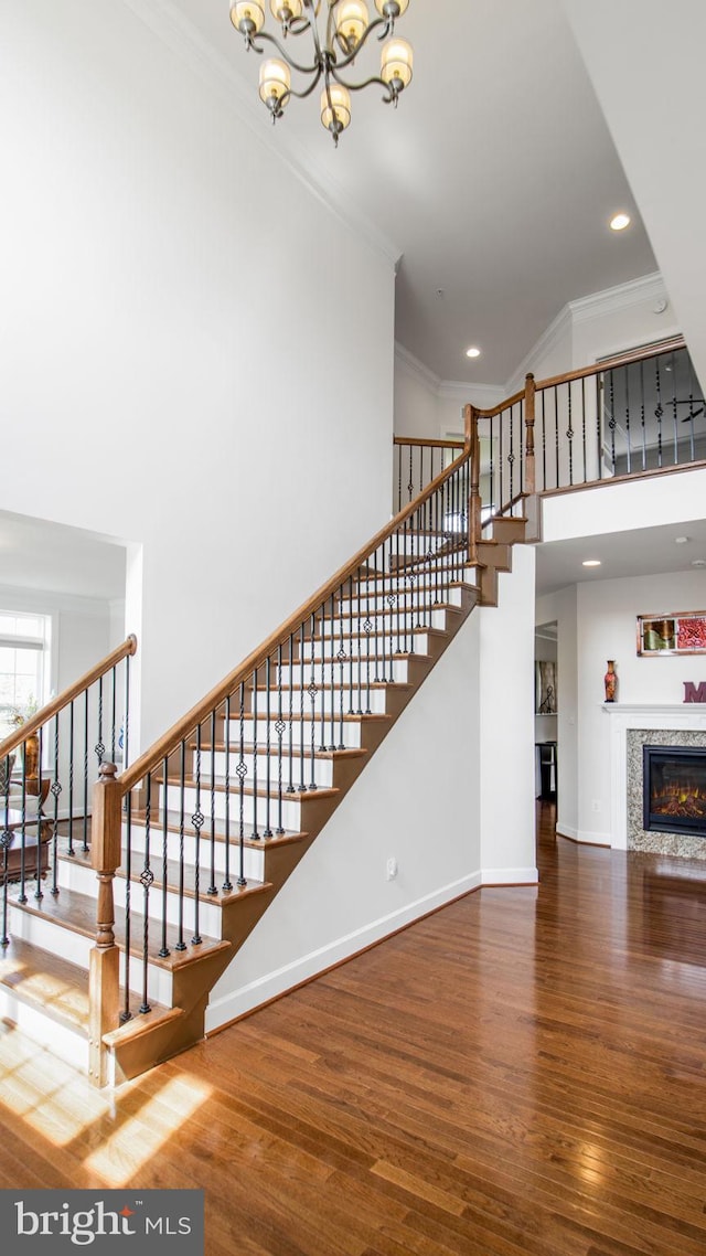 13002 Walkers Ln, Bowie, MD 20721 - stairway with a notable chandelier, ornamental molding, wood finished floors, and a towering ceiling