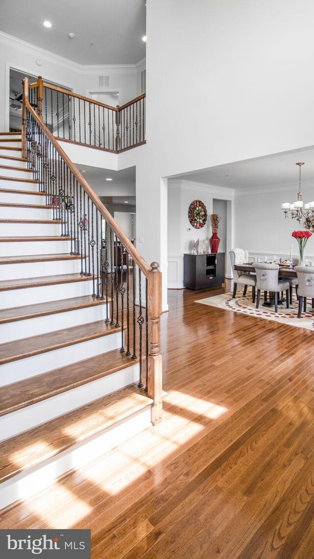 13002 Walkers Ln, Bowie, MD 20721 - stairs featuring crown molding, a high ceiling, visible vents, and an inviting chandelier