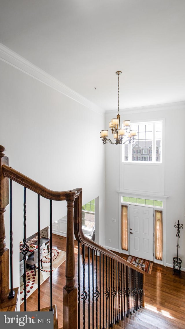13002 Walkers Ln, Bowie, MD 20721 - staircase with an inviting chandelier, ornamental molding, a wealth of natural light, and wood finished floors
