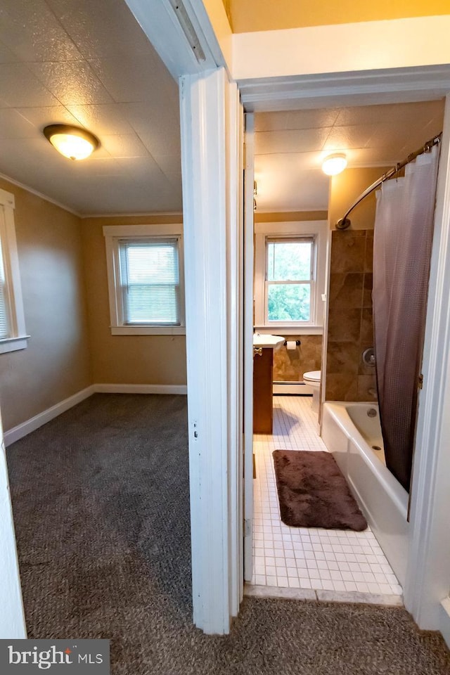 bathroom with baseboard heating and shower / bath combo with shower curtain
