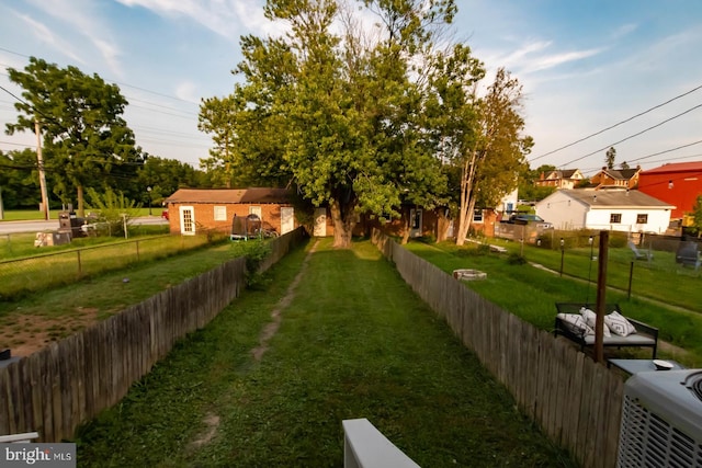view of yard with central air condition unit and fence