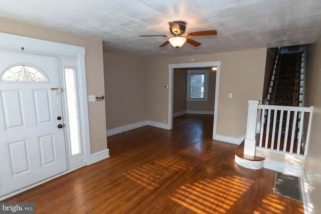 entrance foyer with wood finished floors, visible vents, baseboards, and ceiling fan
