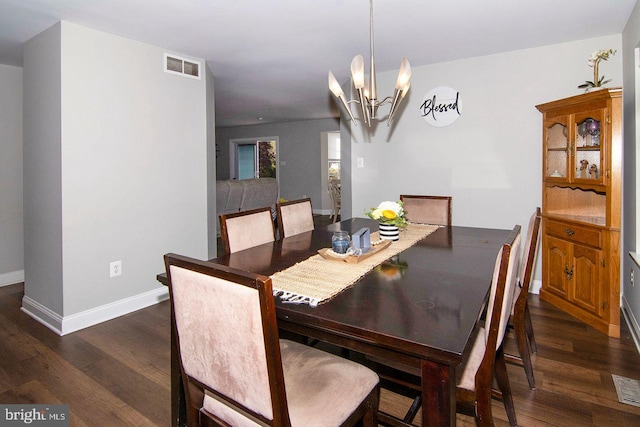 dining room featuring baseboards, visible vents, dark wood-style floors, and an inviting chandelier