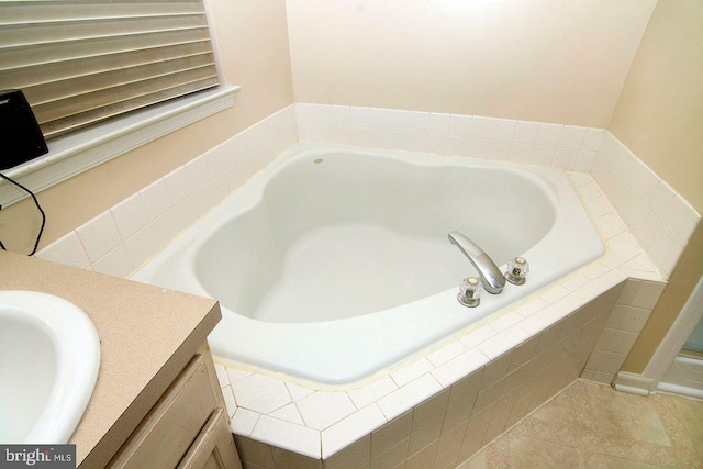 bathroom featuring vanity, tile patterned floors, and a bath