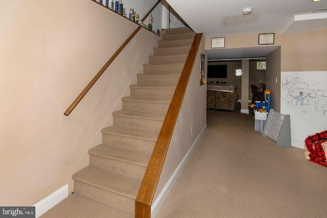 staircase featuring baseboards, carpet flooring, and visible vents