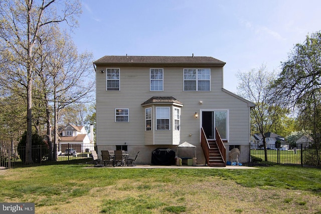 rear view of house featuring entry steps, a patio, a yard, and a fenced backyard